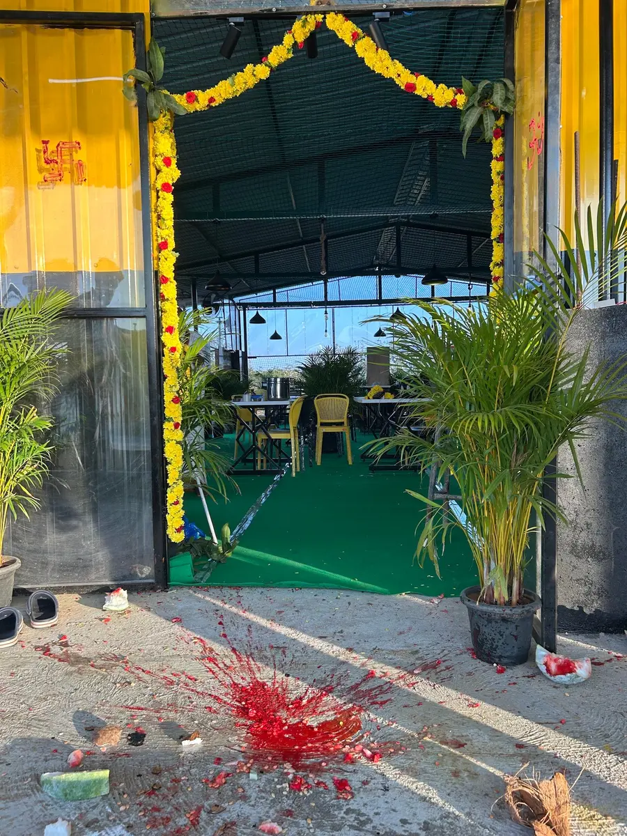 The rooftop entrance hung with marigold garlands and mango leaves on opening day, potted palms either side of a green turf floor.